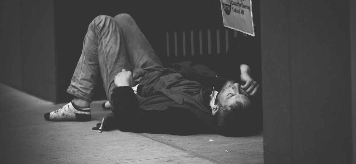 man lying on floor in grayscale photography